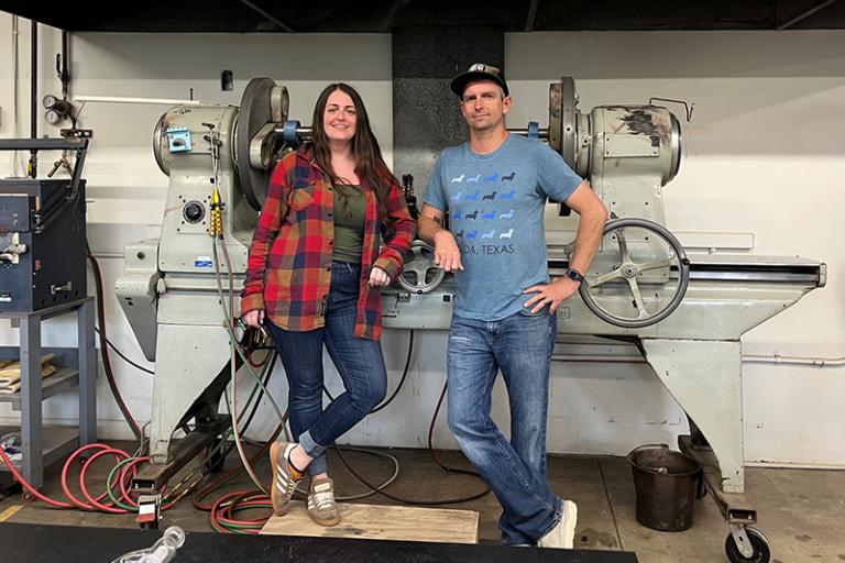 Image of artists Katie Severance and Stephan Peirce standing in front of a glass lathe