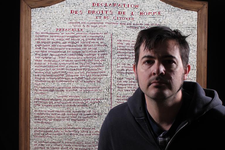 Image of artist Mathieu Grodet in front of a murrine created artwork by Grodet